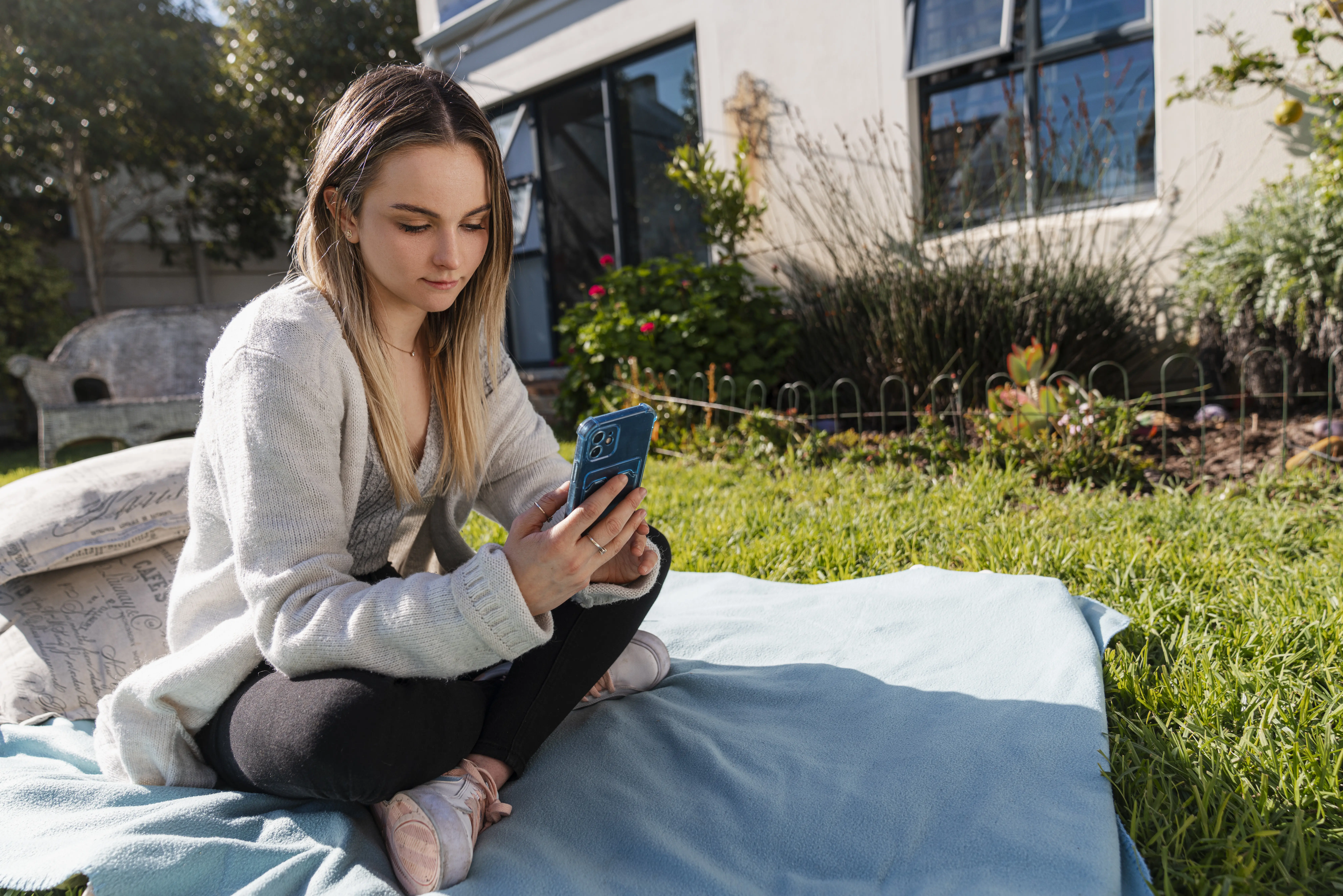 Full-length shot of a woman using a smartphone outdoors.